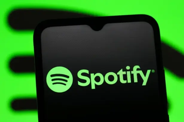Spotify music streaming app displayed on a smartphone with headphones.